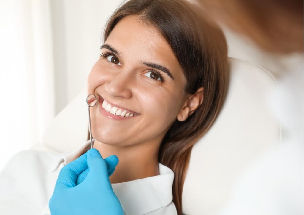 Smiling patient during a cosmetic dental evaluation discussing bonding or veneers as treatment options for enhancing the appearance of front teeth.