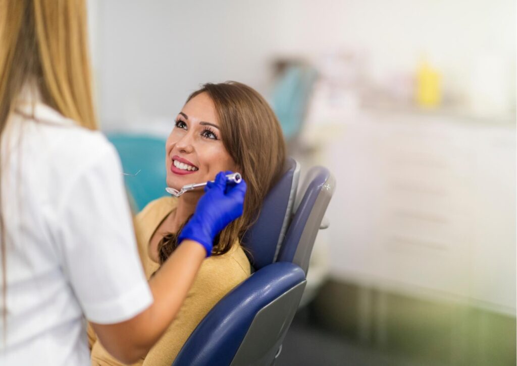 Dentist discussing porcelain veneers with a patient during a follow-up visit to evaluate veneer condition and expected lifespan.