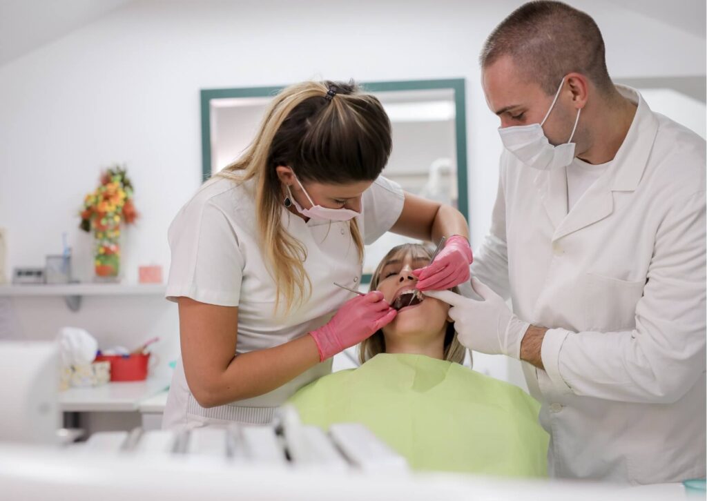 Dentists examining a patient with symptoms of a tooth infection during a comprehensive dental evaluation.