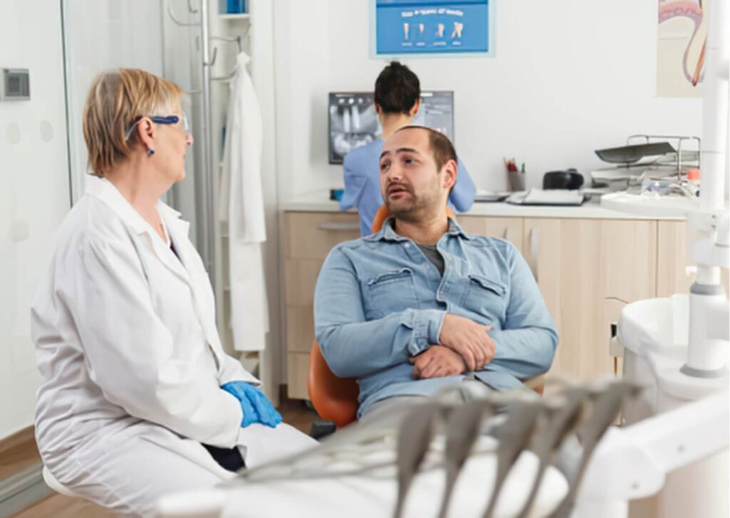 Dentist discussing recovery instructions with a patient after a root canal, including guidance on driving safely after the procedure.