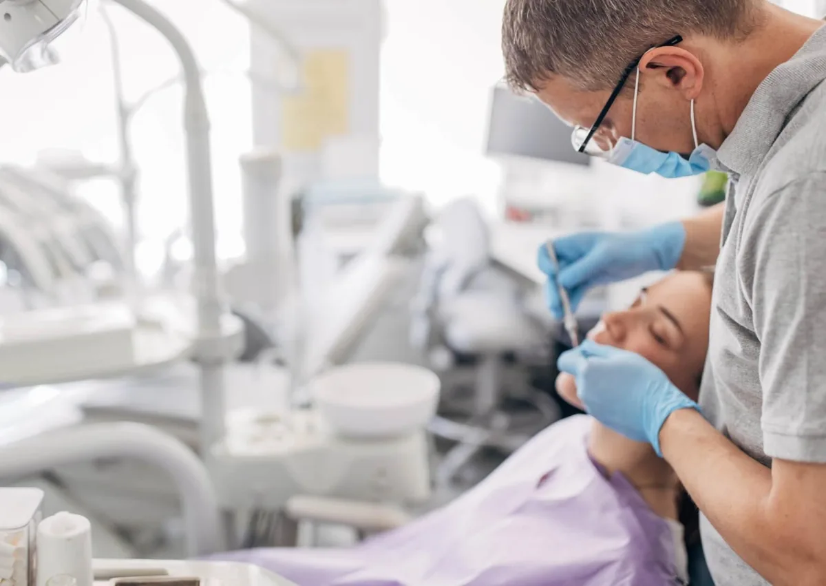 Dentist examining a patient during evaluation for full mouth dental implants.