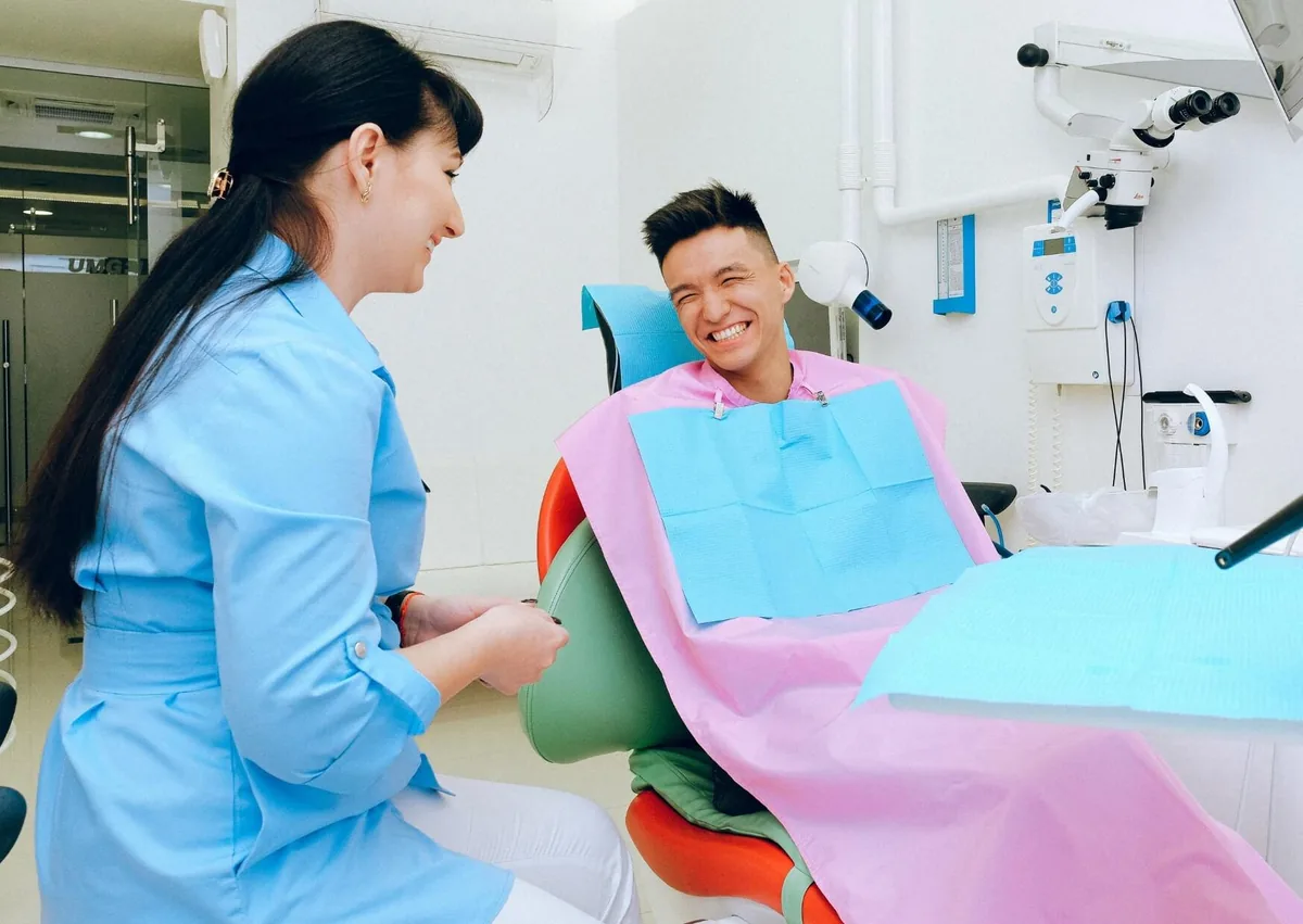 Patient discussing when to resume eating solid foods after wisdom teeth removal with a dental professional.