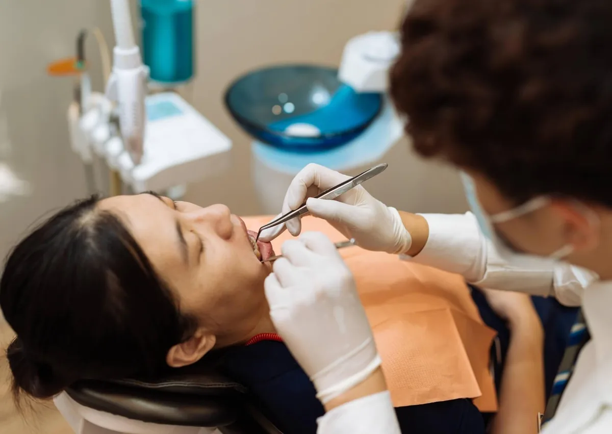 Dentist examining a patient’s mouth for signs and oral health effects of dry mouth.