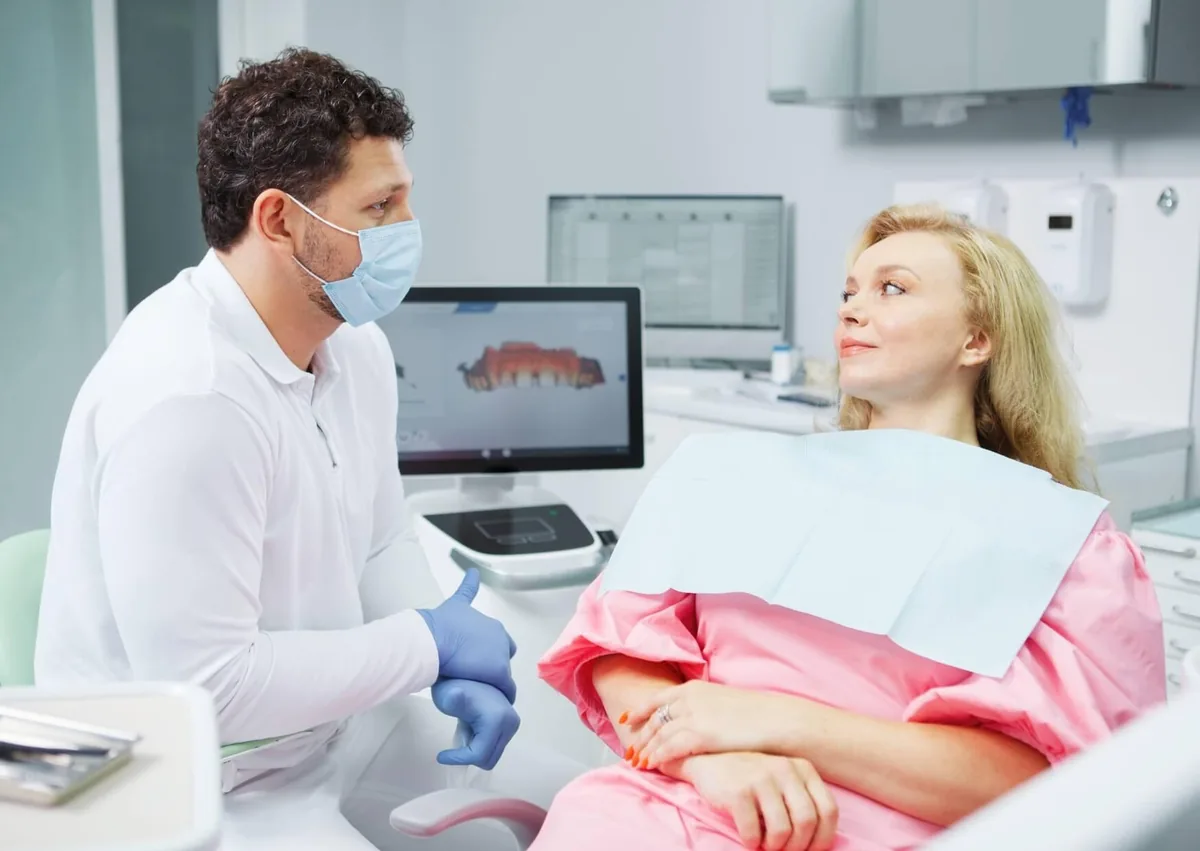Dentist discussing tooth development and dental anatomy with a patient during a consultation about how many teeth humans have.