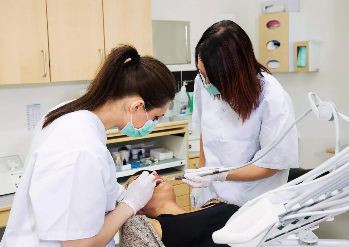 Dental professionals treating a patient during a dental procedure before discussing recovery and what to eat after wisdom teeth removal.